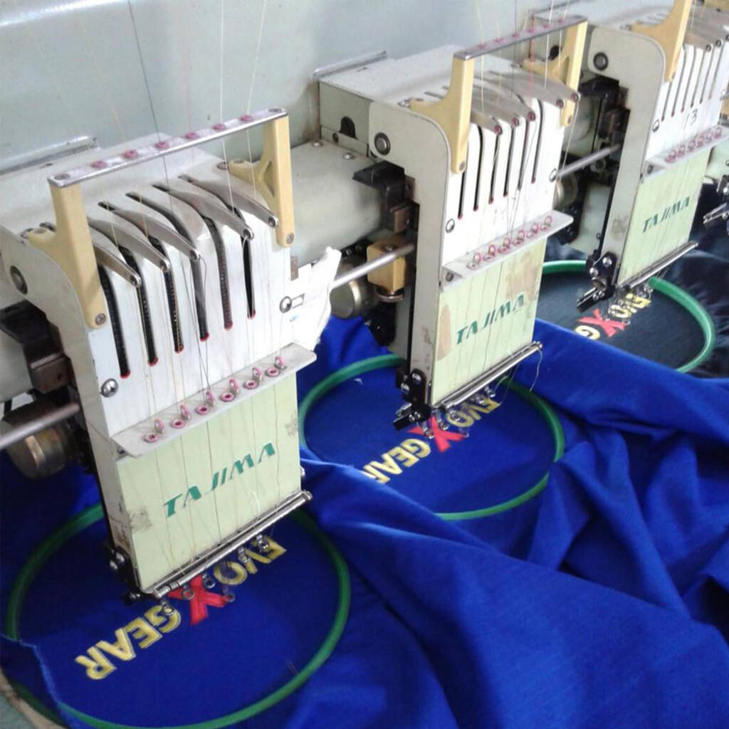 High-precision embroidery machine stitching logos on boxing, MMA, BJJ, and fightwear apparel.